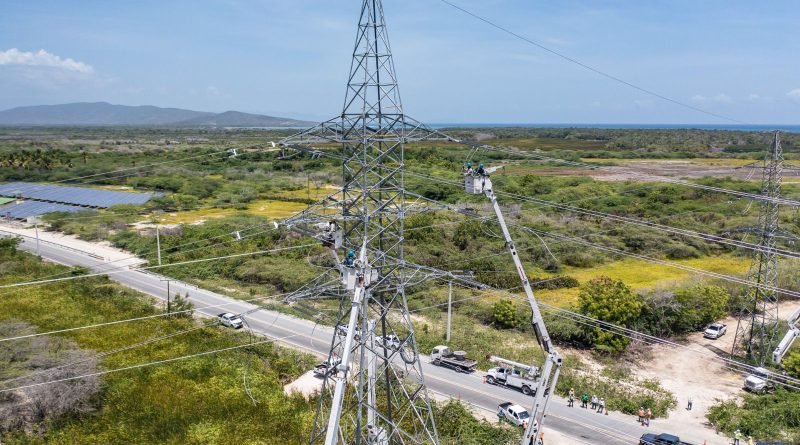 Torre de transmisión eléctrica con técnicos en labores de mantenimiento