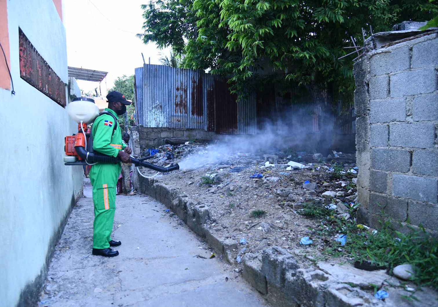 Brigadista de Salud Pública fumigando un callejón en un operativo contra el dengue