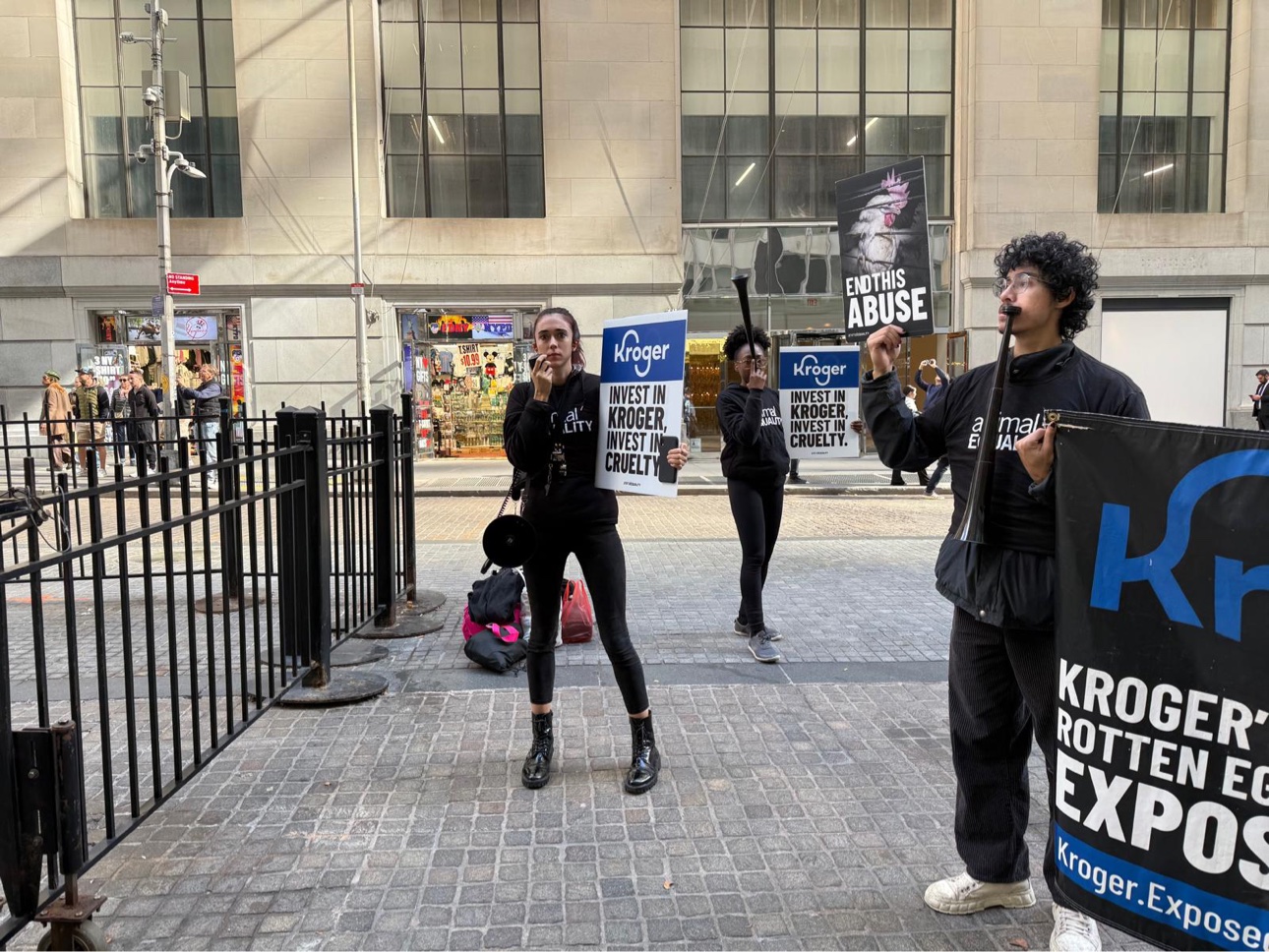 Activistas con carteles contra Kroger frente a la Bolsa de Nueva York