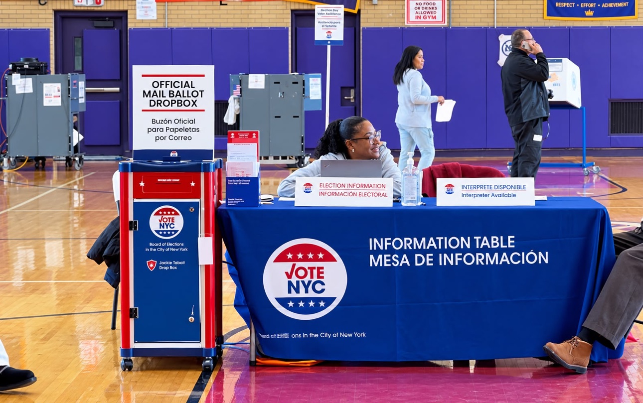 Mesa de información electoral de Vote NYC y buzón oficial de papeletas por correo en un centro de votación anticipada de Nueva York