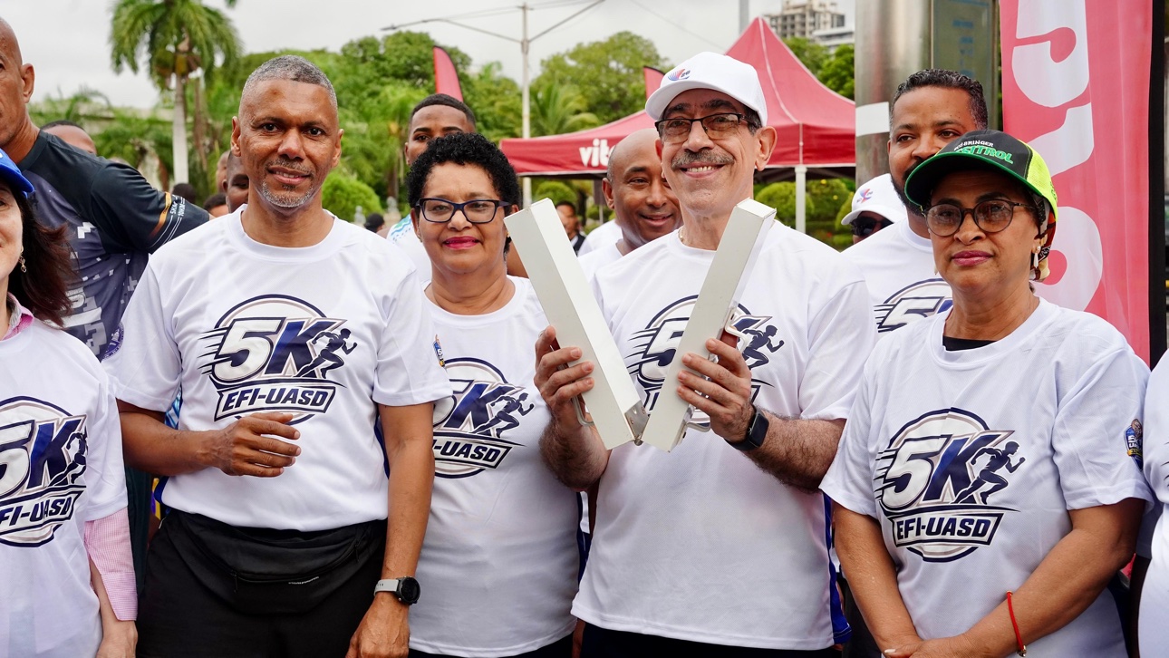 El rector Jorge Asjana David sostiene los bloques de salida junto a miembros de la familia universitaria durante la jornada
