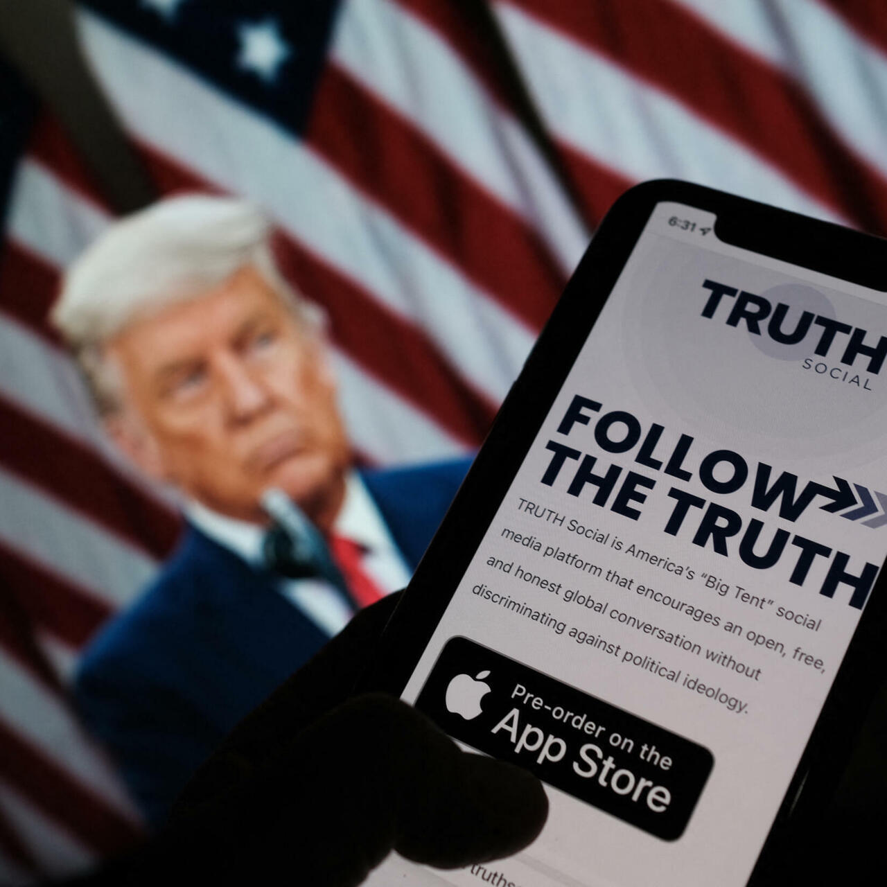Donald Trump al fondo y un teléfono con la pantalla de Truth Social